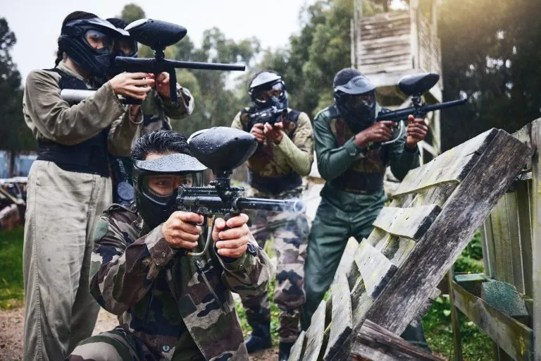 Paintball, military team and shooting training of friends and soldier group with gun. Target exercise, sport game and weapon sports of army men in camouflage together for outdoor games in uniform